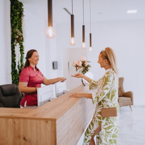 Dental receptionist helps patient at desk