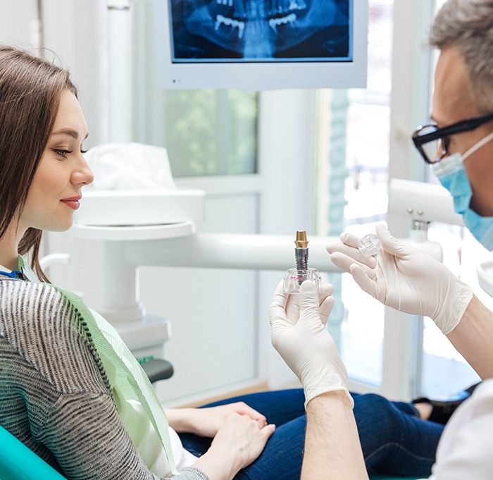 A dentist talking to his patient about dental implant failure and salvage