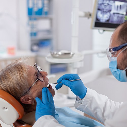 A dentist assessing his patient for dental implant salvage