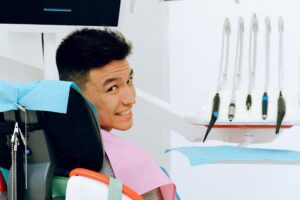 Smiling man in dentist’s chair looking over his shoulder